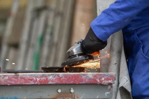main équipée d'un jeune en train de poncer un objet