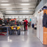 Ateliers des classes de CAP maintenance des véhicules, avec 2 élèves au loin et des véhicules